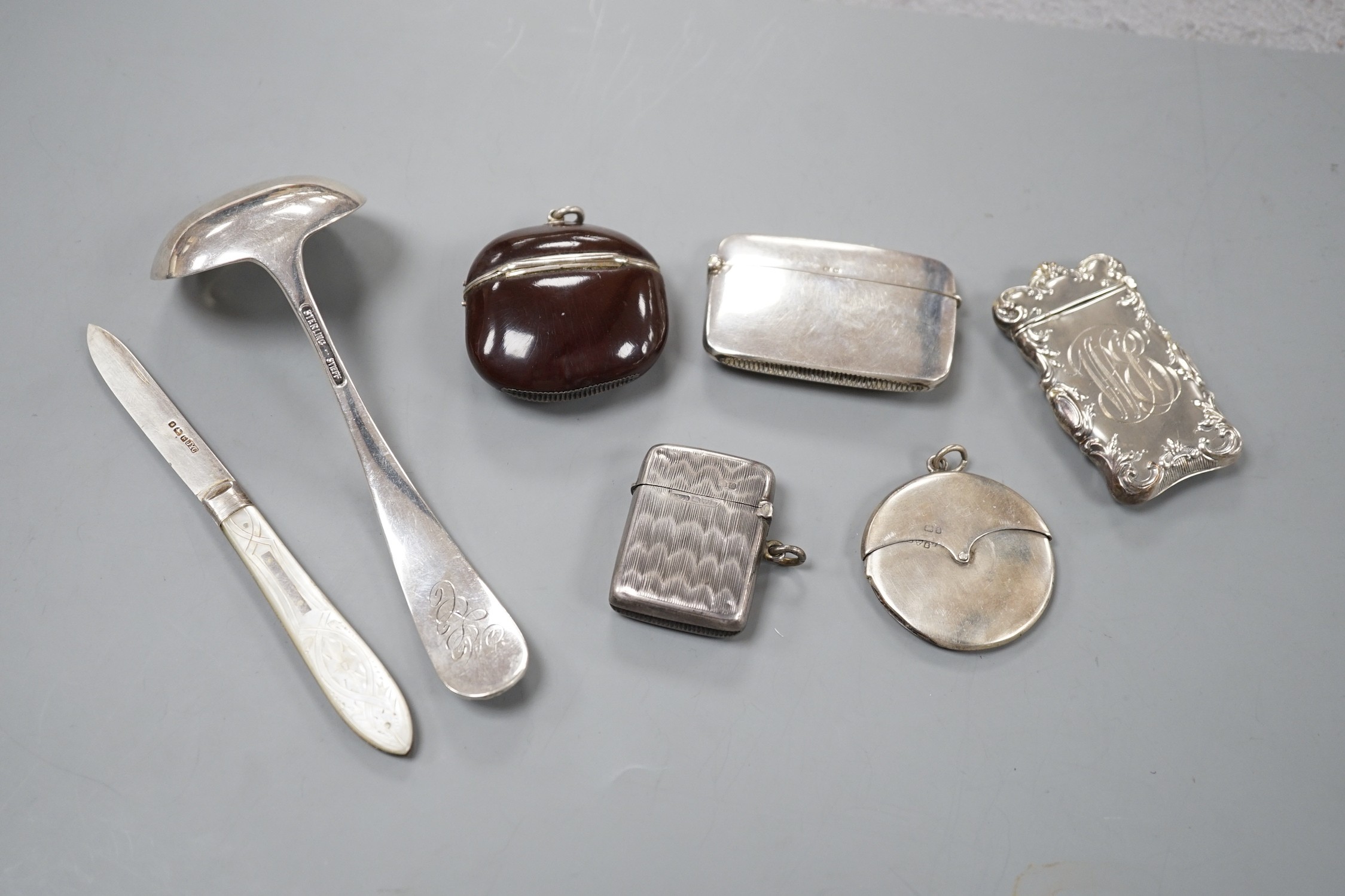 Four assorted early 20th century silver vesta cases, including a silver gilt mounted nut, and patent action circular, together with a sterling vesta case and ornate handled sauce ladle and a mother of pearl handed silver